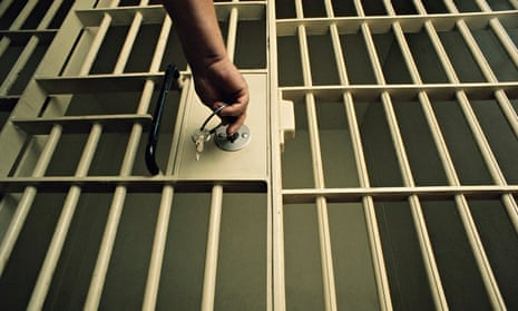 A man locking/unlocking a prison cell door