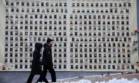 People pass a wall covered with portraits of Ukrainian soldiers who have died in the conflict in eastern Ukraine, in downtown Kiev.