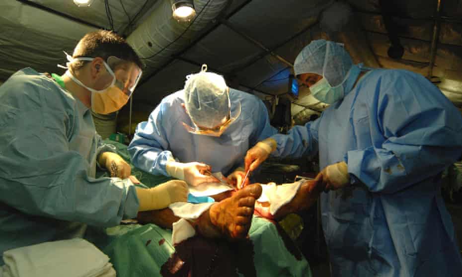 British surgeons and nurses operate on a soldier at a field hospital in Afghanistan.