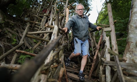 Lars Vilks in Sweden standing on a wood scuplture