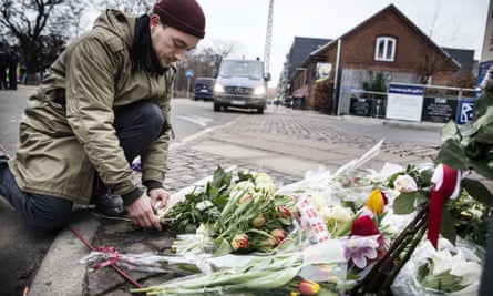 A man lays flowers outside the synagogue in Copenhagen after two deadly shootings.