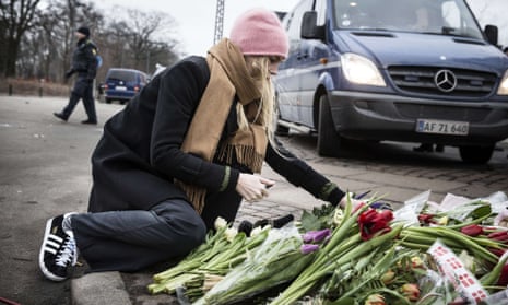 Woman lays flowers at Copenhagen synagogue