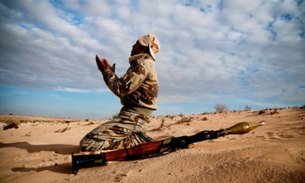 A rebel soldier praying before the start of a new attack against Muammar Gaddafi's forces in early 2011.
