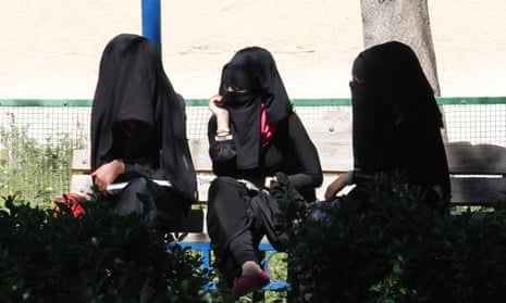 Veiled women sit on a bench in Raqqa