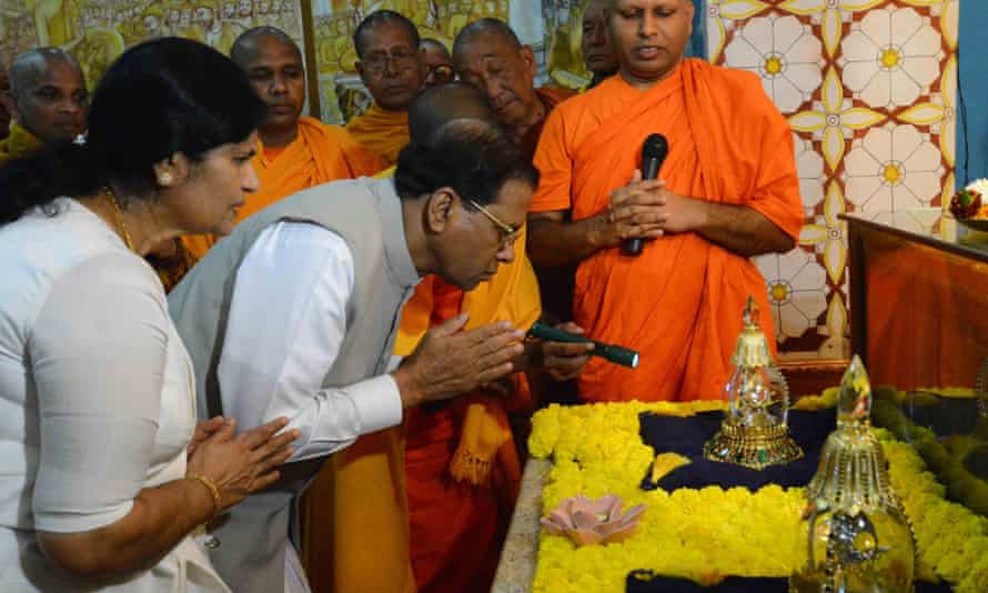 President Maithripala Sirisena and his wife, Jayanthi Sirisena, look at a case believed to hold a relic of Lord Buddha, at a temple in Bodh Gaya, India.