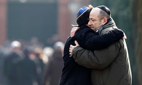 Men embrace at the funeral of security guard Dan Uzan