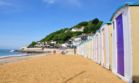 Beach huts at Ventnor. The Spyglass Inn can be seen in the distance.