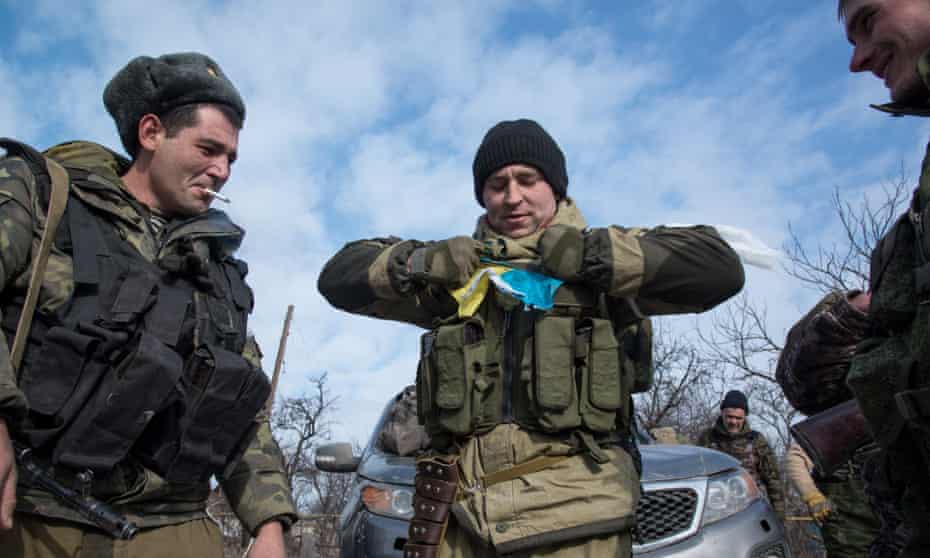 Pro-Russia fighters tear apart a Ukrainian flag