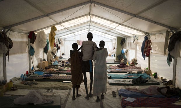 A photo released taken on 13 January 2015 by Doctors Without Borders shows a man suffering from Kala azar (centre) assisted by his wife (right) and a relative at a hospital in Lankien, South Sudan. The conflict has left people more vulnerable to the deadly tropical disease.