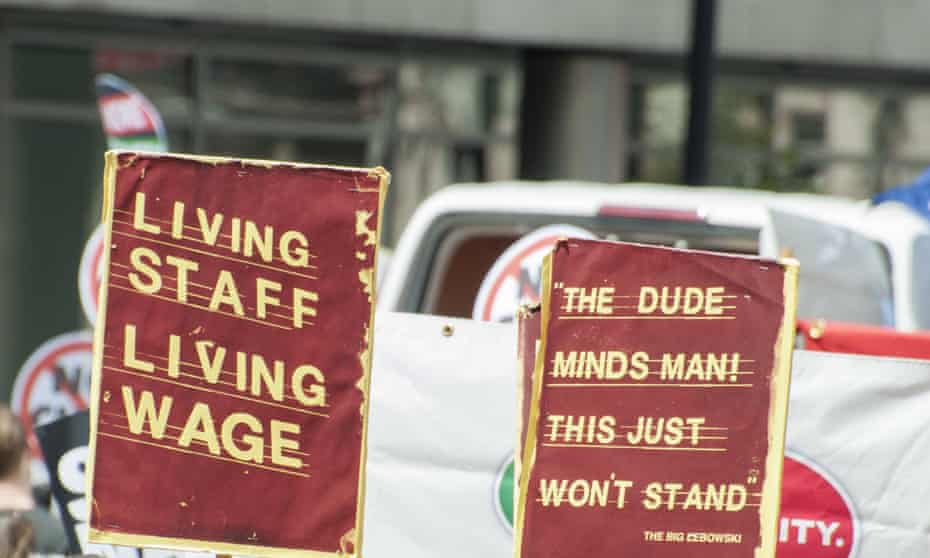 Campaigners with banners reading 'Living Staff, Living Wage' at a London demonstration.