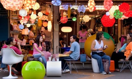 Shoppers relax at a cafe decorated with various colorful lamps at Bangkok’s Chatuchak market.