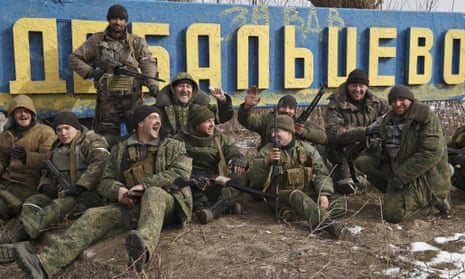 Russia-backed rebels pose by a road sign at the entrance to Debaltseve