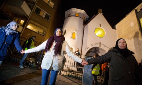 Jews and Muslims hold hands as they join in a ring of solidarity around the synagogue in Oslo, in a peace vigil that drew a crowd of 1,300 people.