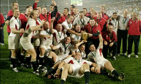 The England rugby team celebrate victory on the pitch.