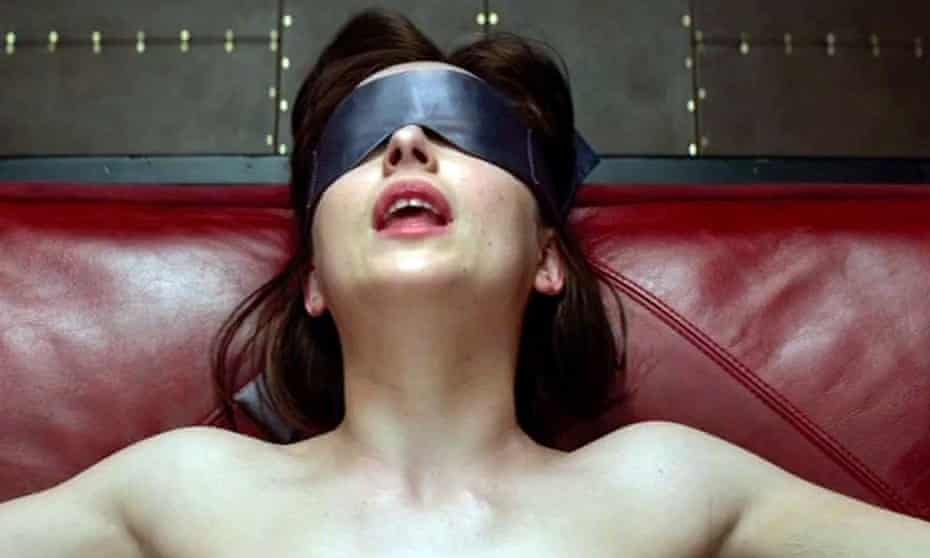A still from the film of Anastasia Steele (played by Dakota Johnson) wearing a blindfold.