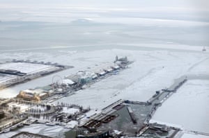 Snow coats Navy Pier surrounded by ice covered Lake Michigan in Chicago