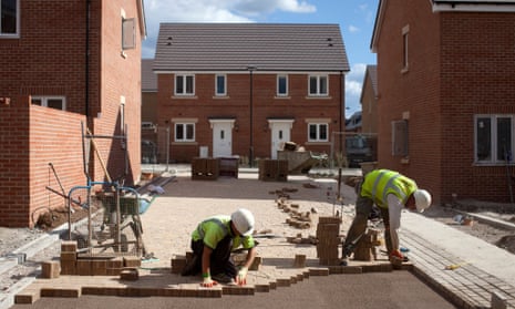 Builders lay bricks for a driveway at a Persimmon  site.