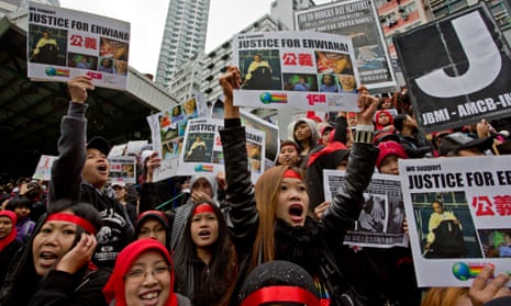 Domestic helpers shout slogans while holding pictures of 23-year-old Indonesian maid Erwiana Sulistyaningsih during a protest in Hong Kong, in January 2014. Erwiana was allegedly assaulted for nearly eight months before the family she worked for sent her back to Indonesia.