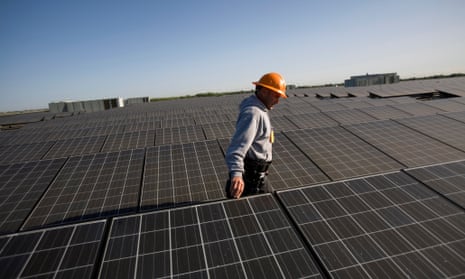 A solar technician employed by SunEdison checks the rooftop array of solar panels above the 514,000 square foot Walgreens distribution center in Woodland, California.