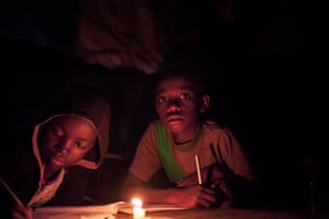 In a the Mathare slums of Nairobi, Davie and Nyadutu study by candlelight sometimes aided by the glare from a neighbour’s television. Improving education is a key development goal, but many children in poorer countries, like these, face considerable handicaps.