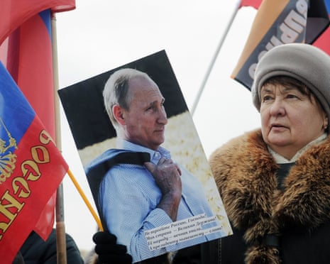 A woman carrying a portrait of Vladimir Putin takes part in an Anti-Maidan rally.