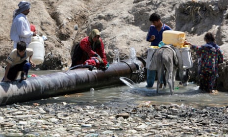 Iraqis fill drinking water and wash clothes at a broken water pipeline in a Shia district of Sadr City, Baghdad.