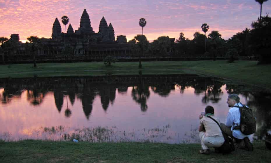 Tourists visit the temples of Angkor, Cambodia, at dawn.