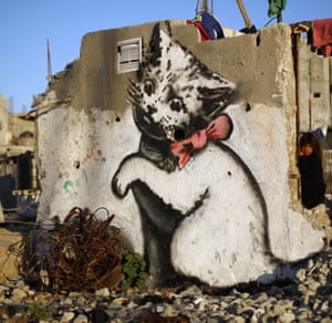 A kitten plays with a ball of mangled steel, in a mural painted by Banksy in the Palestinian town of Beit Hanun, on the Gaza Strip.