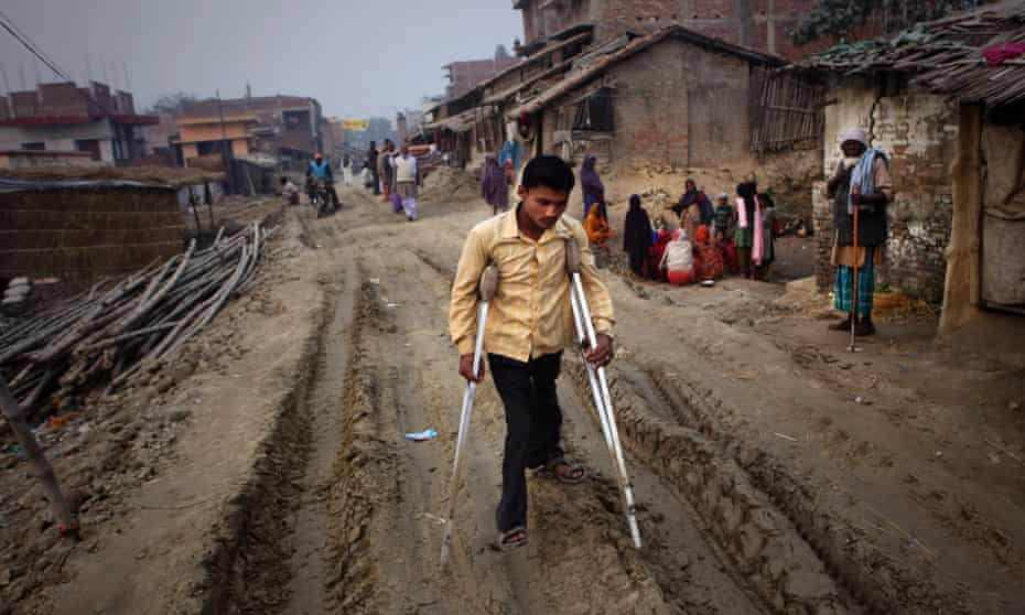 man uses crutches on a dirt track