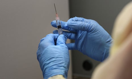 Gloved hands of Liberian pharmacist preparing Ebola vaccine