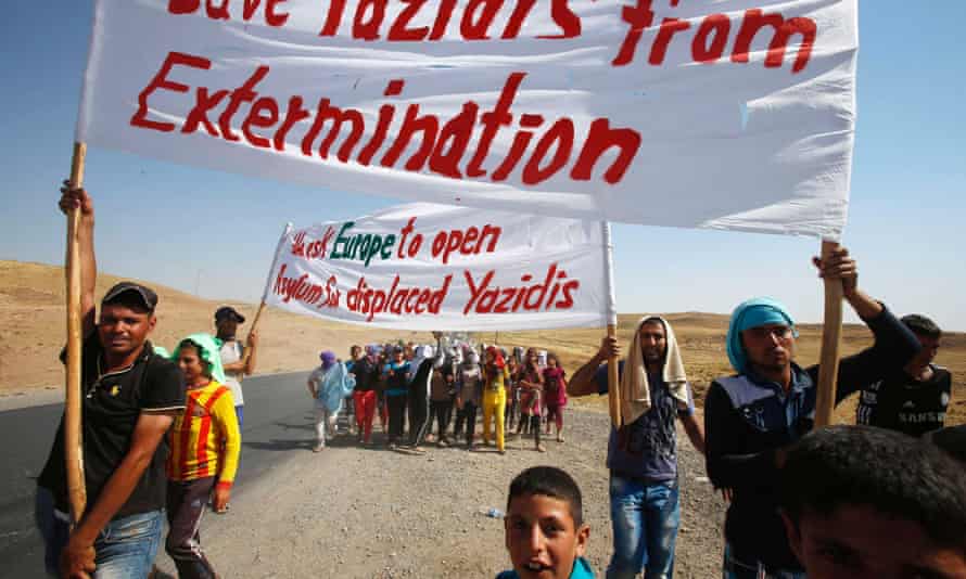 Save our people: displaced Yazidi, who fled the violence in the Iraqi town of Sinjar, hold banners as they take part in a demonstration at the Iraqi-Syrian border crossing in Fishkhabour.
