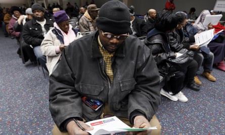 David White pores over paperwork at Detroit's Cobo Center along with hundreds of others waiting for their foreclosure cases to be heard on 29 January 2015.
