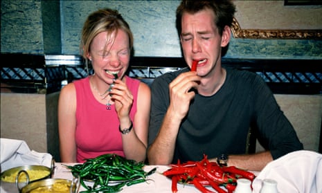 A couple eating chillies.