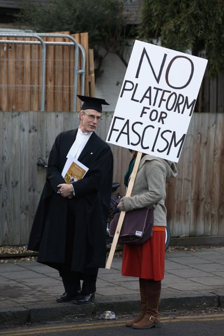 A proctor talking to a student protesting about Marine Le Pen's appearance at Cambridge University Student's Union in 2013.