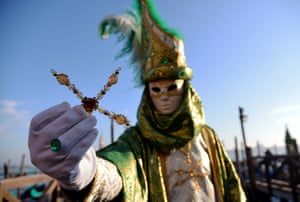 The <em>volto</em> mask is commonly worn with a cloak and often a tricorne hat - although this participant has teamed it with a bishop’s mitre and jewelled cross