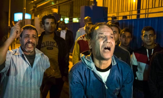 Relatives of Zamalek soccer club fans react and wait outside a morgue in Cairo