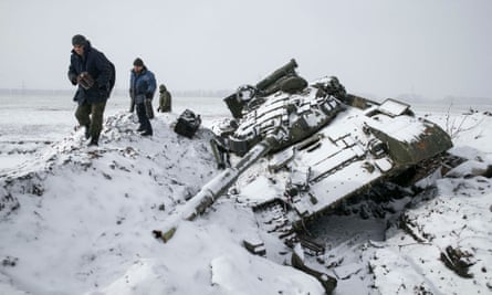 Members of the separatist Donetsk People's Republic army collect parts from a destroyed Ukrainian army tank in the town of Vuhlehirsk.