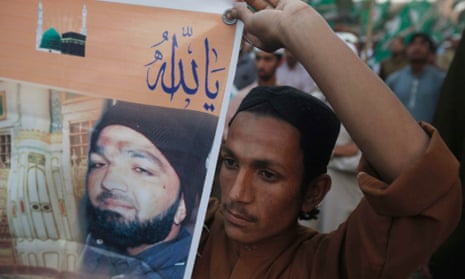 A supporter holds a banner of convicted killer Mumtaz Qadri during a demonstration against his death sentence in Karachi.