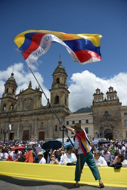 A demonstrator waves a Colombian flag at last week's march in favour of peace talks.