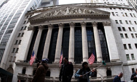 Tourists take pictures with the backdrop of the New York Stock Exchange (NYSE).