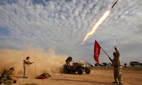 Shia fighters launch a rocket during clashes with Isis militants on the outskirts of al-Alam on 8 March. Photograph: Thaier Al-Sudani/Reuters