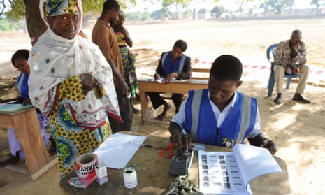 An electoral officer checks the identity of a voter at the Bole polling station, in the Bole Bamboi constituency of northern Ghana, on December 7, 2012.  Ghana voted in a high-stakes presidential election today which is expected to be close, with the emerging country seeking to live up to its promise as a beacon of democracy in turbulent West Africa.