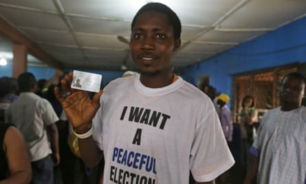 Adesina Afeez Adebare displays his voter's card at an Inec centre.
