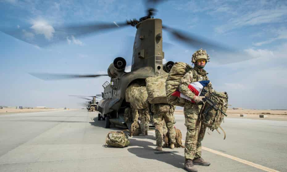 Wing Commander Matt Radnall prepares to board the last Chinook helicopter as the very last British boots to leave Camp Bastion, Helmand Province, Afghanistan.