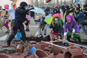 Dressed up demonstrators climb over a blockade
