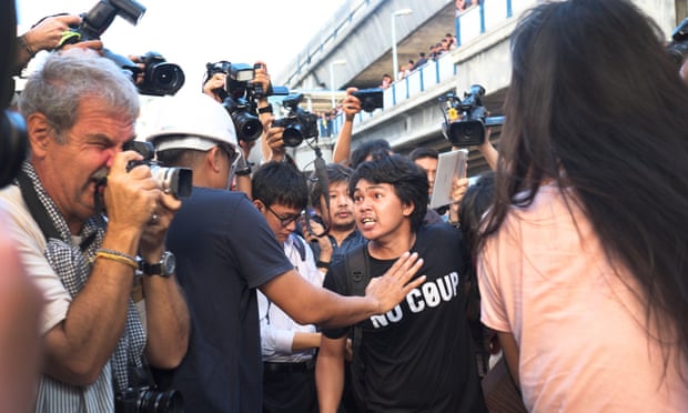 An anti-coup activist fights off being restrained during a demonstration in central Bangkok on Valentines Day after handing out roses and copies of George Orwell's Nineteen Eighty-four.