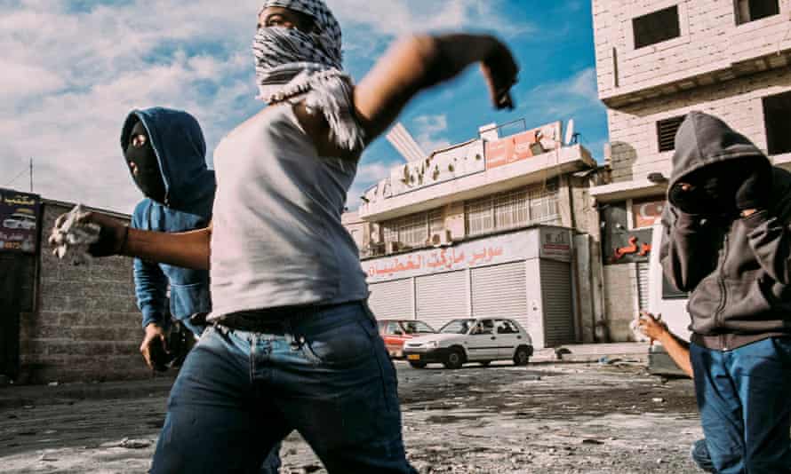 Palestinian youth throw stones at Israeli forces during a clash at the entrance to Shuafat refugee camp in Jerusalem in 2014. 2014, a year characterised by an EU report as the violent and polarised in the city in recent memory.