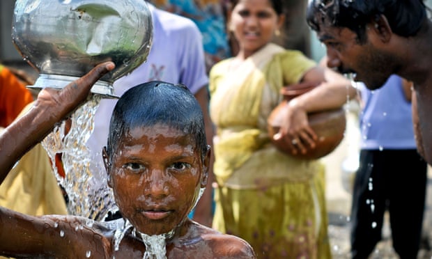Women and children gather water from pumps in India