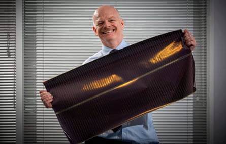 Perry Carroll holding a sample of his innovative, flexible solar cloth.