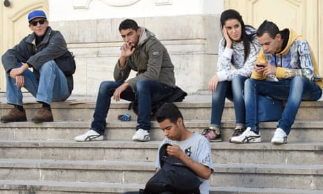 Some of Tunisia’s more than 600,000 unemployed, almost half of whom are graduates from higher education institutions, sit on the steps of a theatre on Tunis’s Habib Bourguiba Avenue.
